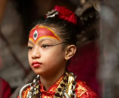 A young girl wearing a red and gold costume