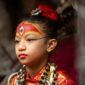 A young girl wearing a red and gold costume