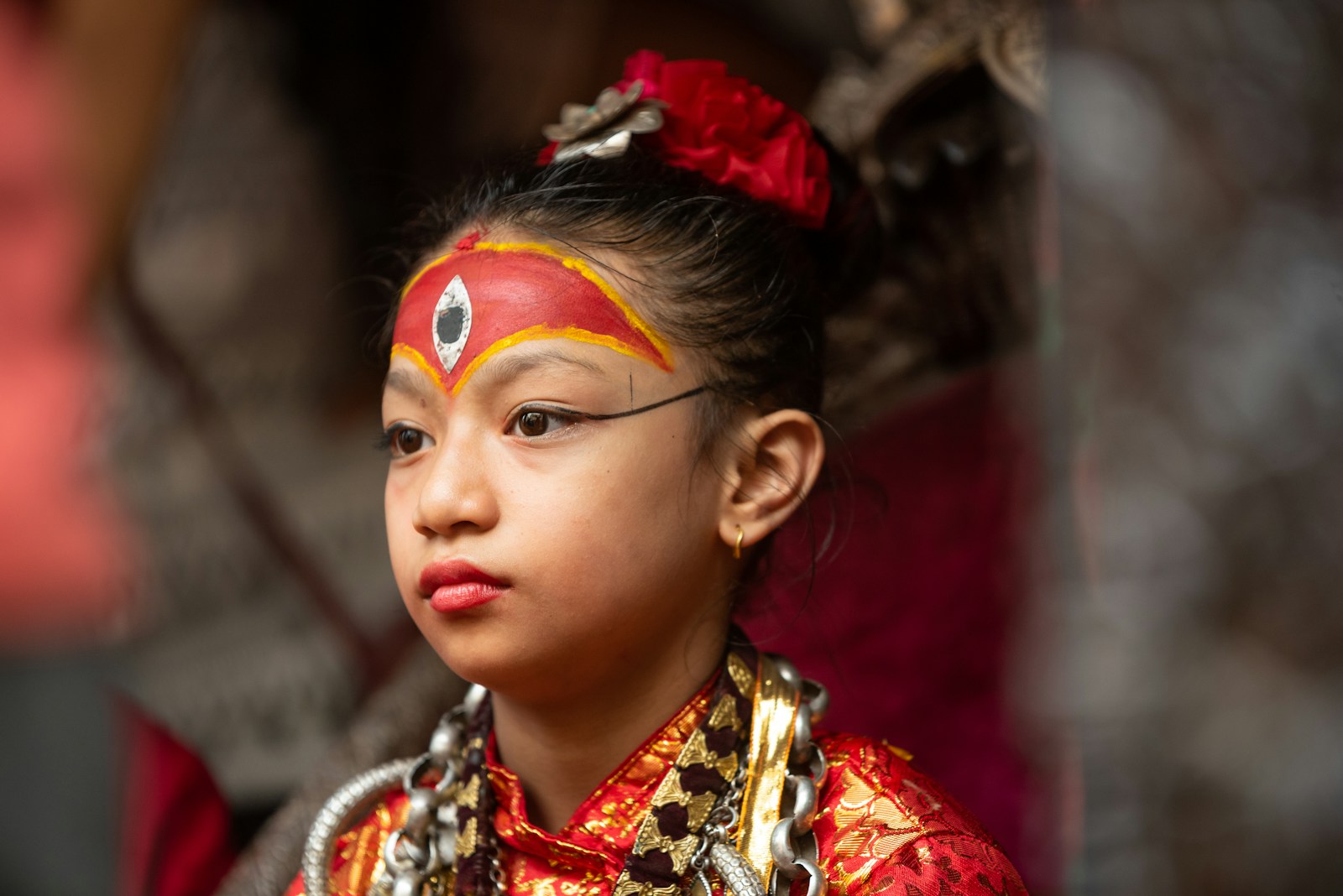 A young girl wearing a red and gold costume