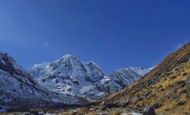 a snow covered mountain range with a clear blue sky