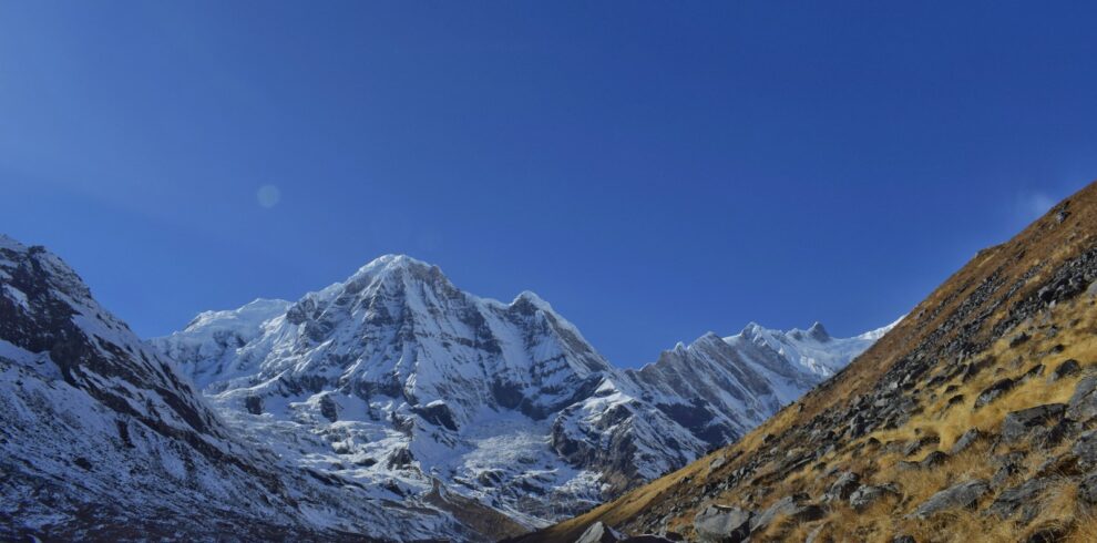 a snow covered mountain range with a clear blue sky